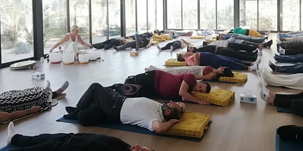 Teambuilding event with Lisa playing crystal bowls to group of people relaxing on the floor